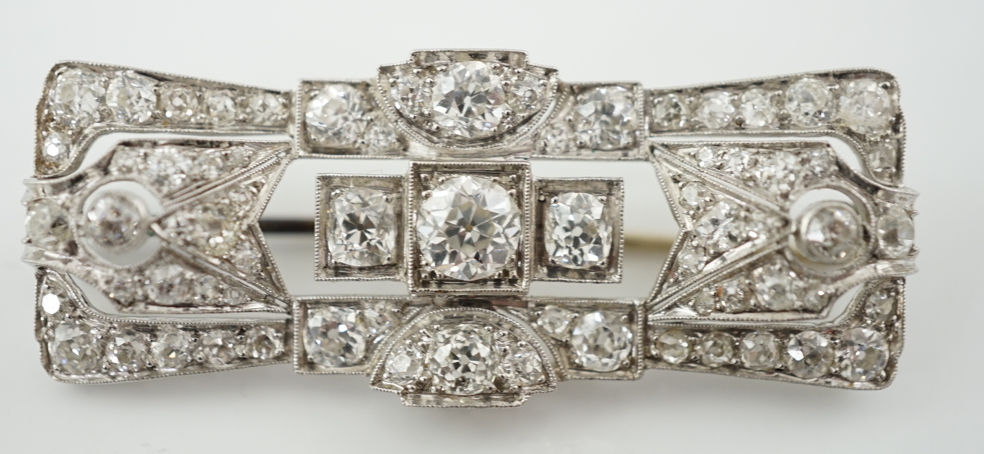 An Art Deco platinum and millegrain set diamond cluster brooch